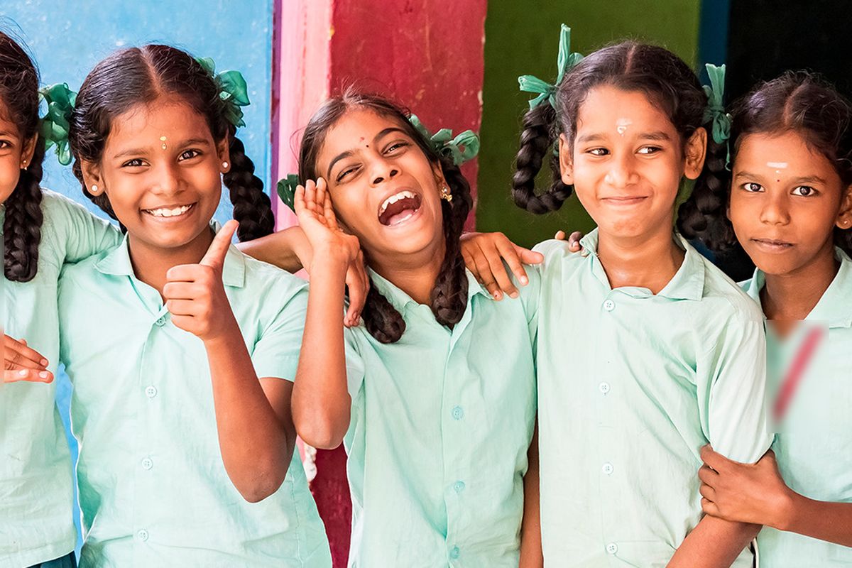 Schoolgirls in uniform smiling together in India (illustrative photo)