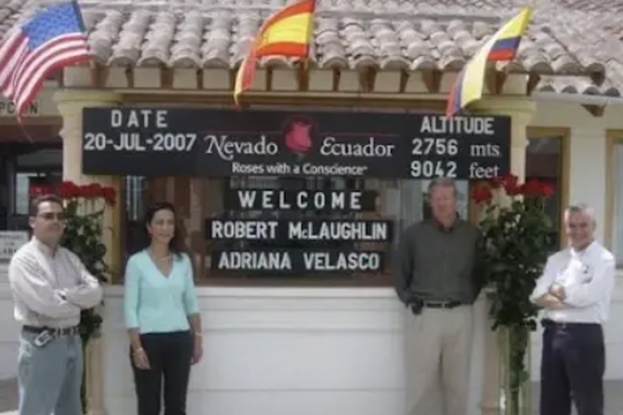 Robert McLaughlin and Adriana Velasco with two farm leaders under the Nevado Ecuador welcome sign, July 20, 2007